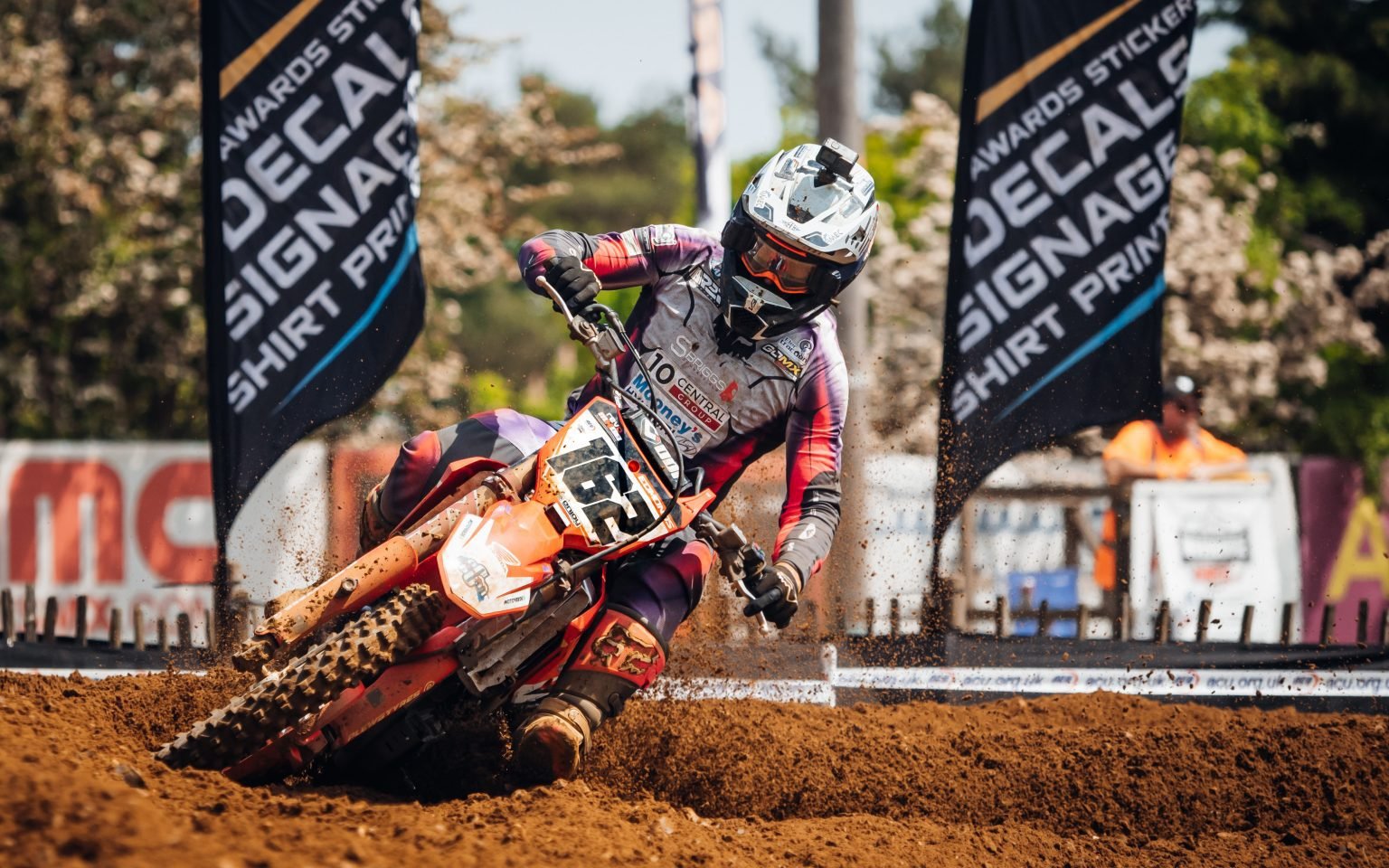 Motocross racer navigating through a rutted muddy area of a track. Pic is zoomed in on just the front tire and front forks of the motocross bike to highlight the Plews Tyres front tire.