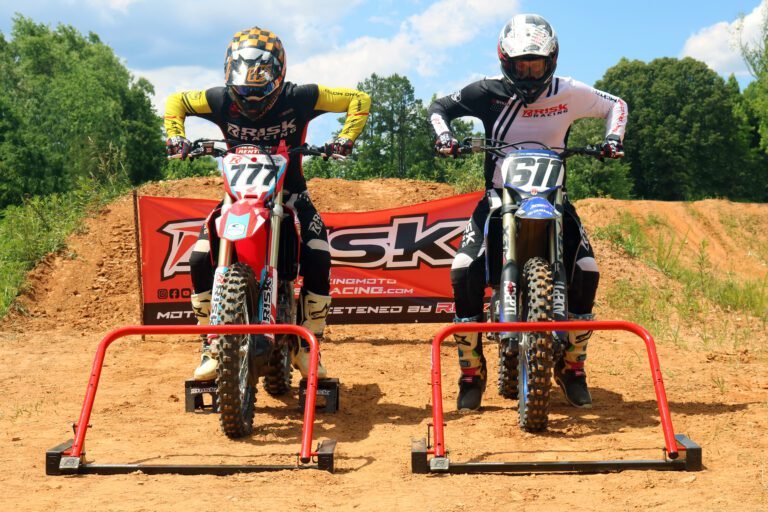 Oudoor picture of two MX riders lined up at Holeshot Pro Gates aimed right at camera