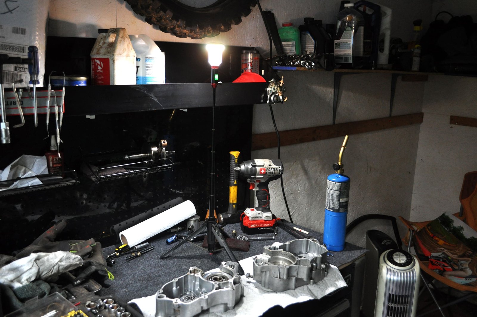 Workshop with tools and equipment on a cluttered workbench. Work area lit up by a FLi-MORPHE 28 in telescoping lantern.