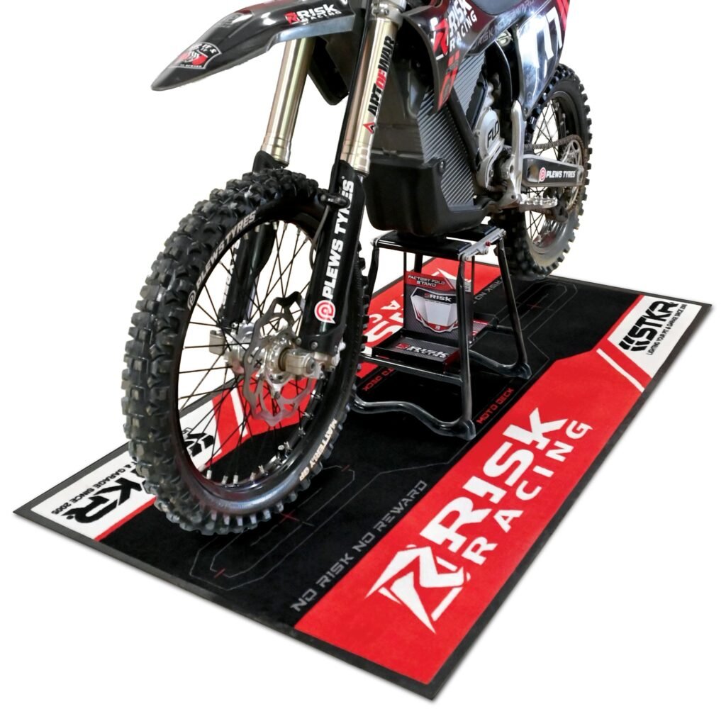 Dirt bike on the Risk Racing Carpeted Pit Mat with a bike stand