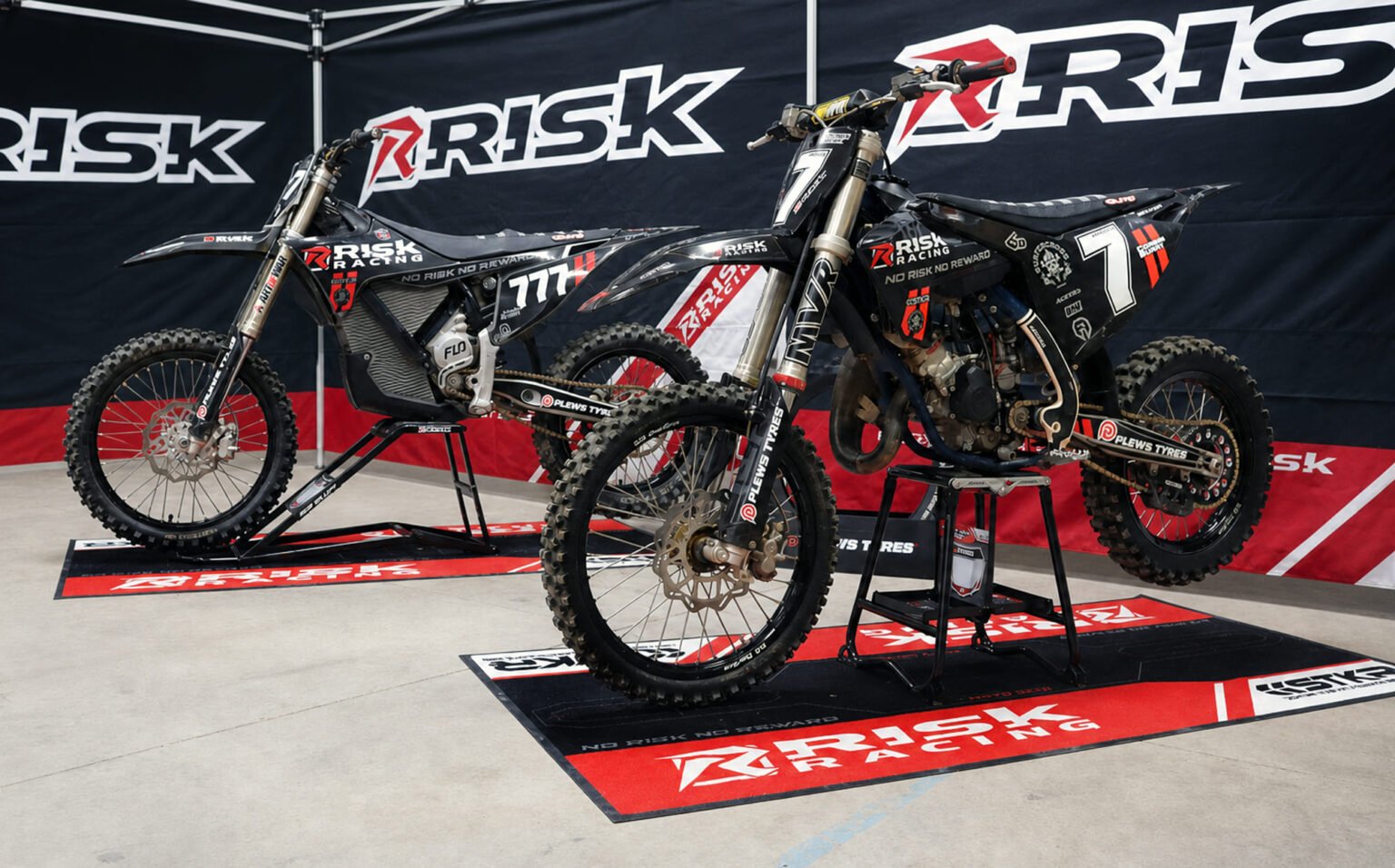 Risk Racing pit setup with bikes arranged on the Carpeted Pit Mat