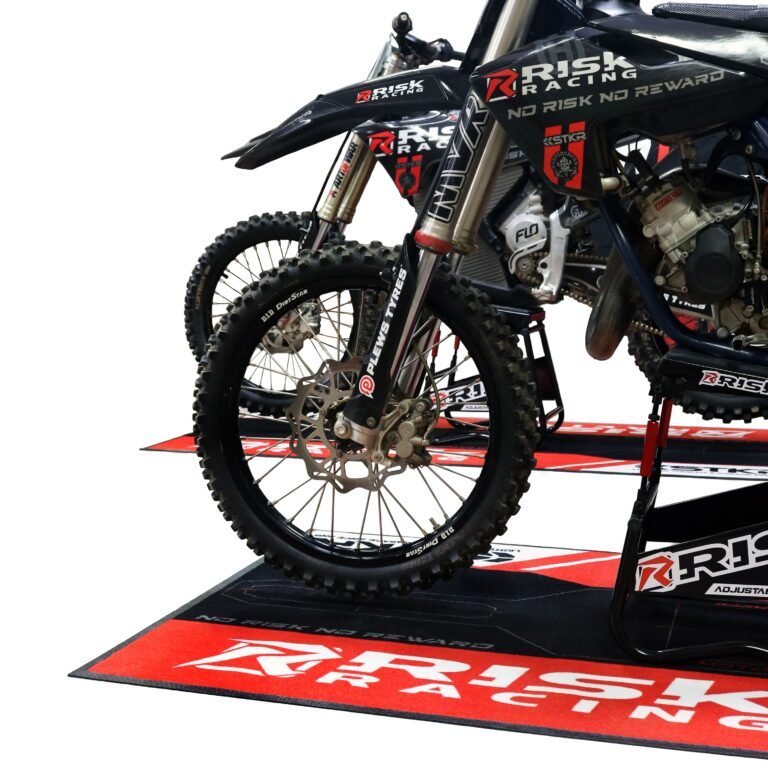 Two motocross bikes and stands staged on Risk Racing Carpeted Pit Mats